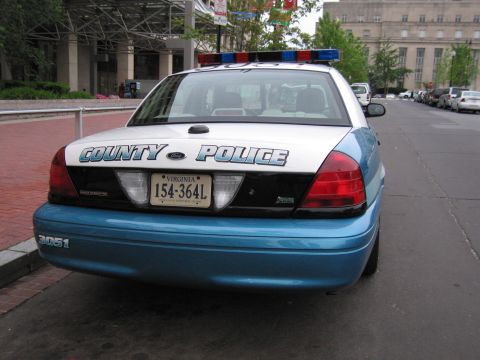 1991 Ford Crown Victoria - This police car has "COUNTY POLICE" written on the trunk and a light bar on the roof.