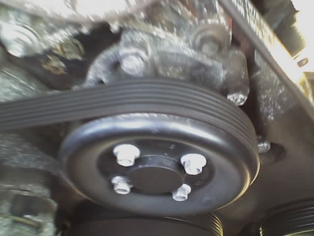 Close-up of a car's engine belt and pulley system