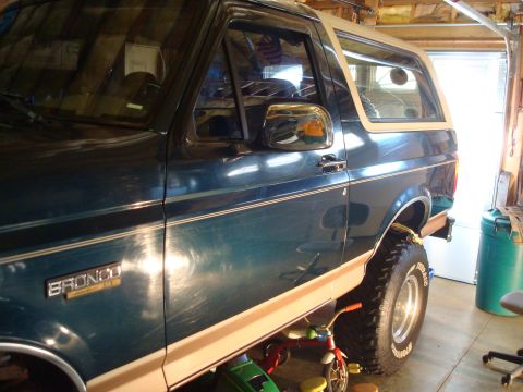 1995 Ford Bronco - Side view of a 1995 Ford Bronco parked inside a garage.