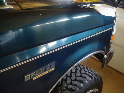 1995 Ford Bronco - Close-up of the fender and tire of a teal 1995 Ford Bronco, showing the "BRONCO" badging.