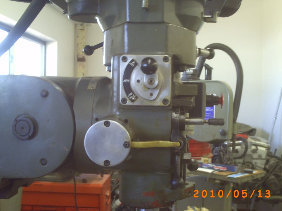 Green industrial milling machine with control dials and levers, close-up view