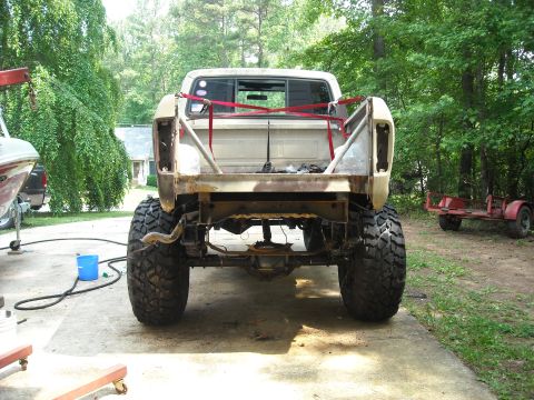 1979 Ford F-150 - Rear view of a modified 1979 Ford F-150 pickup truck with large off-road tires and a custom roll cage.