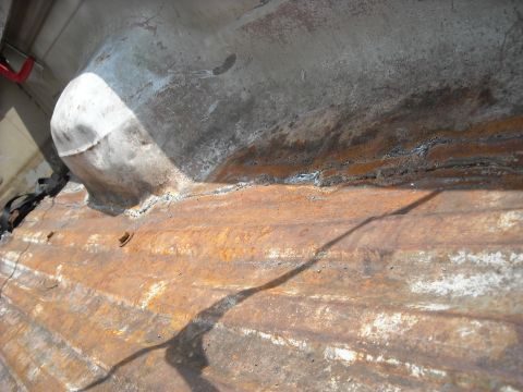 1979 Ford F-150 - Close-up of heavily rusted corrugated metal, possibly a vehicle undercarriage part.