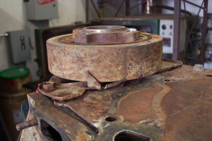 Heavily rusted engine pulley assembly bolted to an engine block