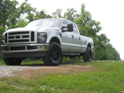 2008 Ford F-250 - This silver pickup truck, likely a 2008 Ford F-250, is shown from a 3/4 front angle with prominent black wheels.