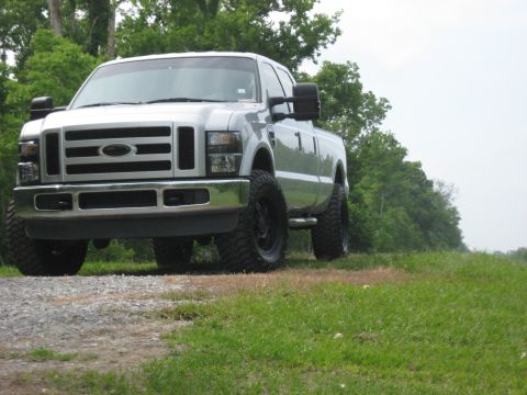 2008 Ford F-250 - Silver 2008 Ford F-250 pickup truck with aftermarket wheels and tires parked on a gravel road.
