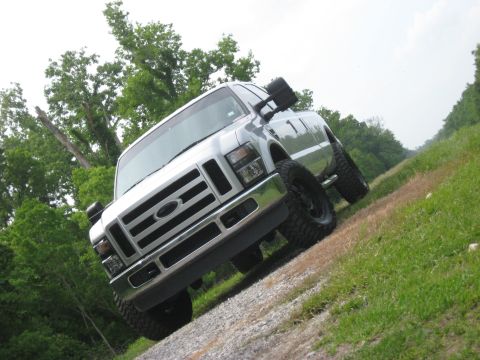2008 Ford F-250 - This 2008 Ford F-250 pickup truck is shown from a 3q-front angle, parked on a gravel road with grassy hillsides.