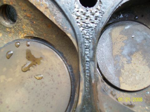 1972 Ford Ranchero - Close-up of an engine cylinder head with visible rust and water, indicating potential internal damage.