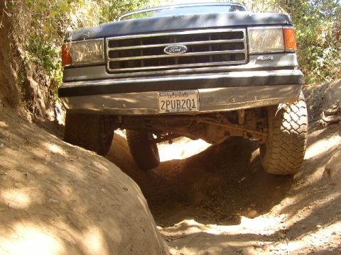 1989 Ford Bronco - Ford Bronco navigating a steep, rocky trail with its front end angled upwards.