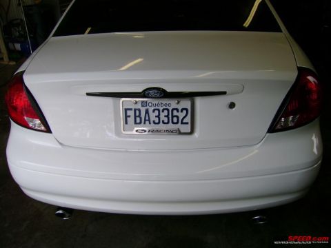 1993 Ford Taurus - Rear view of a white sedan with a Quebec license plate and dual exhaust pipes.