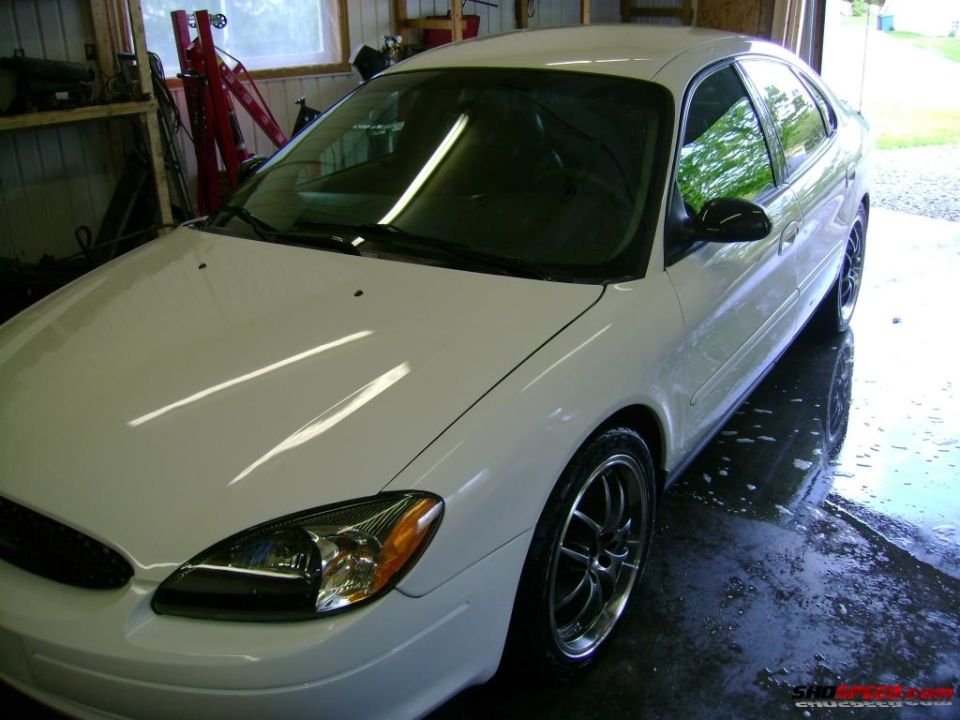 White sedan, 3/4 front view. Likely a 2000-2007 Ford Taurus