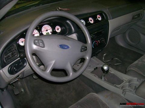 1993 Ford Taurus - Interior view of a 1993 Ford Taurus, aftermarket gauges and a Ford steering wheel.