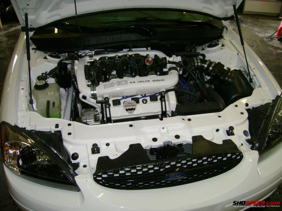 1993 Ford Taurus SHO engine bay with white intake manifold and black engine components