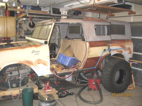 1961 International Scout 800 - A 1961 International Scout 800 is shown in a garage with its doors removed, indicating it is in the process of restoration or has undergone…