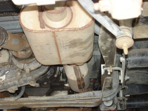 1992 Ford Bronco - The undercarriage of a vehicle reveals its exhaust system and suspension components.
