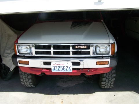 1988 Suzuki Samurai - Front view of a Toyota pickup truck, possibly a 1989 model, parked in a garage.