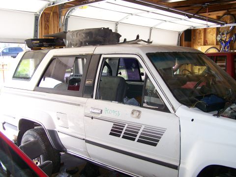 1988 Suzuki Samurai - This white SUV, likely from the mid-1980s, is seen from a three-quarter front angle inside a garage.