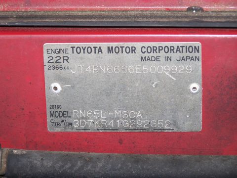 1988 Suzuki Samurai - Close-up of a VIN plate on a red vehicle, indicating a Toyota Motor Corporation 22R engine.