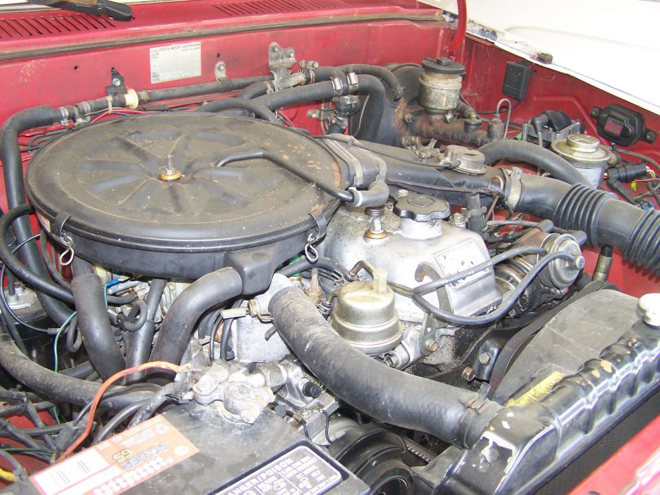 engine bay with air cleaner, radiator, and battery visible