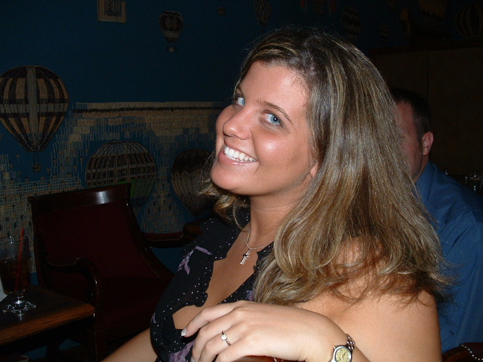 Person seated indoors at a table with a hot-air-balloon mural behind them