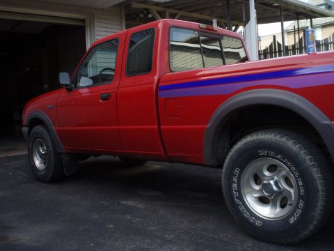 1997 Ford Ranger - A red 1997 Ford Ranger pickup truck with distinctive racing stripes is parked in a driveway.