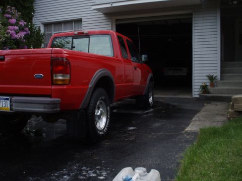 1997 Ford Ranger - Rear 3/4 view of a red 1997 Ford Ranger pickup truck parked in a driveway.