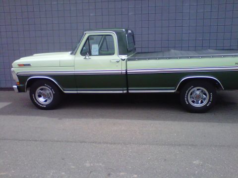 1995 Ford Bronco - Side view of a two-tone green and cream 1970 Ford pickup truck with a bed cover.