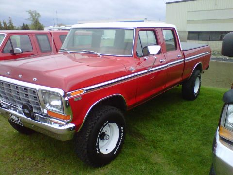 1995 Ford Bronco - This red crew cab pickup truck, likely a 1979 Ford F-Series, is seen from the front-three-quarter angle with a white roof and chrome accent…