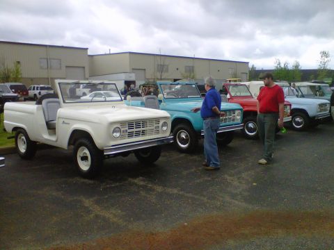 1995 Ford Bronco - Several Ford Broncos are lined up in a parking lot, with a white one in the foreground.