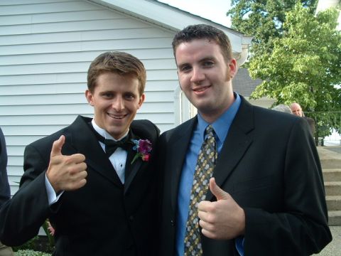 1993 Ford Taurus - Two men in formal wear pose for a photo outside a building, both giving a thumbs-up gesture.