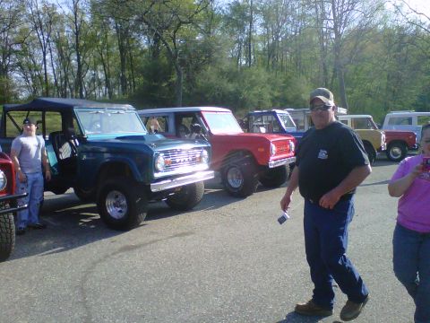 1995 Ford Bronco - Multiple Ford Broncos are lined up outdoors, with people standing around them.