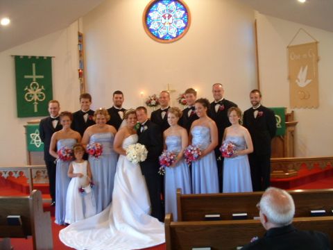1993 Ford Taurus - A wedding party stands together for a formal photograph inside a church sanctuary.