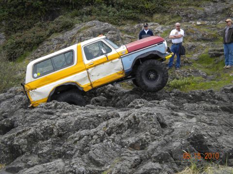 1994 Ford Explorer - This modified SUV is navigating a rocky terrain, with onlookers observing the challenging maneuver.