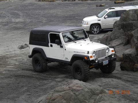 1994 Ford Explorer - White Jeep Wrangler Rubicon and white Cadillac Escalade on sandy terrain.