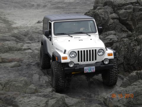 1994 Ford Explorer - A white Jeep Wrangler Rubicon navigates a rocky terrain, with a date stamp of 05 15 2010 in the corner.