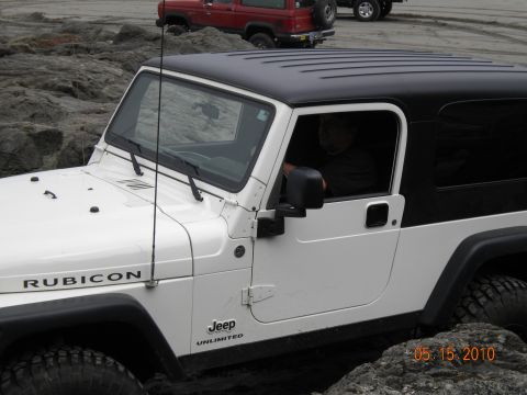1994 Ford Explorer - A white Jeep Wrangler Rubicon navigates rocky terrain, with another vehicle visible in the background.