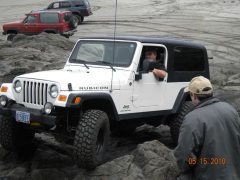 1994 Ford Explorer - A white Jeep Wrangler Rubicon navigates rocky terrain, with other vehicles visible in the background.