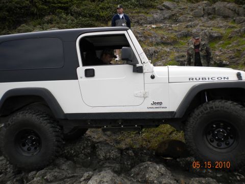 1994 Ford Explorer - A white Jeep Wrangler Rubicon Unlimited navigates rocky terrain with two men standing nearby.