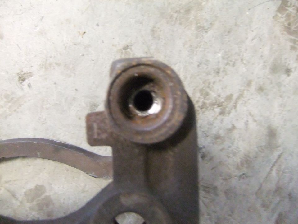 Close-up of a rusty metal automotive part with a hole in the center