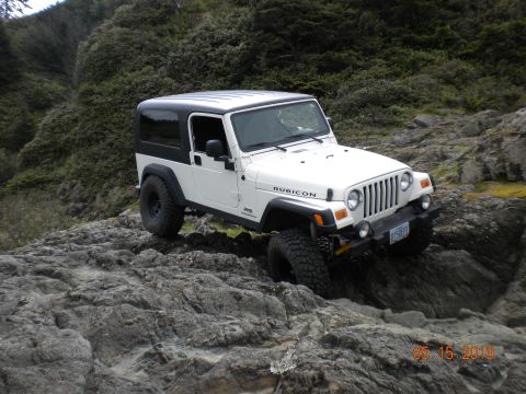 1994 Ford Explorer - Jeep Wrangler Rubicon tackling rough terrain on a rocky coastal path.