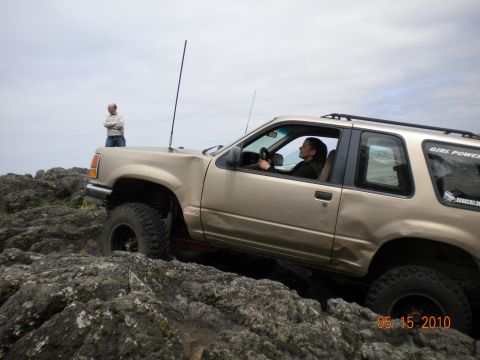 1994 Ford Explorer - A 1994 Ford Explorer navigates a rocky trail with a driver behind the wheel and another person observing.