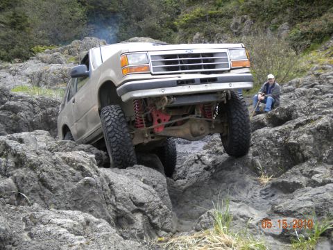 1994 Ford Explorer - A modified 1994 Ford Explorer navigates a rocky off-road course with a spectator watching.