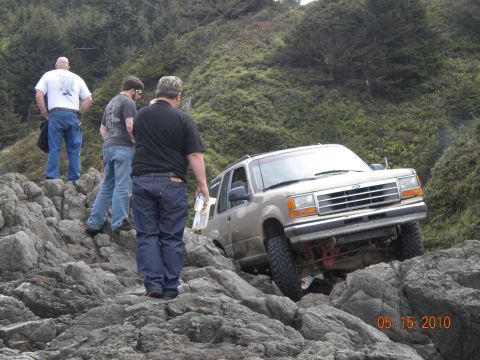 1994 Ford Explorer - A 1994 Ford Explorer navigates a rocky coastal terrain, with onlookers observing its progress.