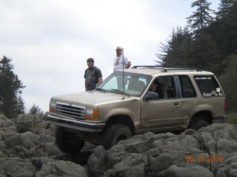 1994 Ford Explorer - A tan Ford Explorer navigates a rocky terrain with two men observing.