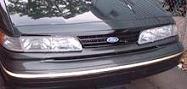 1997 Ford Crown Victoria - Front view of a dark-colored Ford Crown Victoria, showing the grille and headlights.