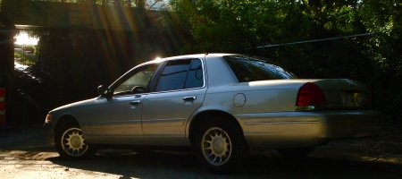 2000 Ford Crown Victoria - Side view of a silver 2000 Ford Crown Victoria sedan parked outdoors.
