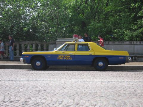 1991 Ford Crown Victoria - A blue and yellow New York State Police car is parked on a cobblestone street.