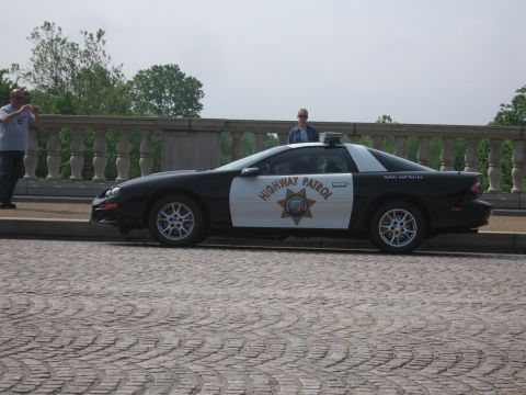 1991 Ford Crown Victoria - A highway patrol car is parked on a cobblestone street with a stone railing in the background.