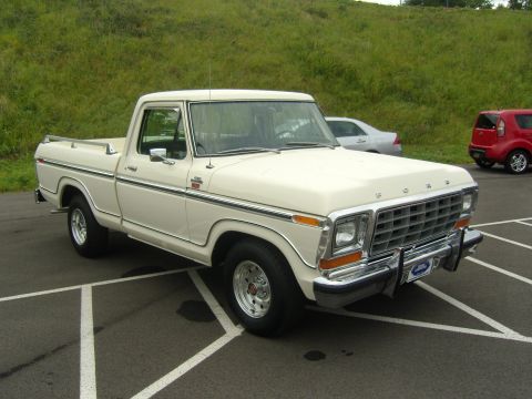 2007 Ford Mustang - A classic white Ford F-150 pickup truck is parked in a lot with other vehicles visible in the background.