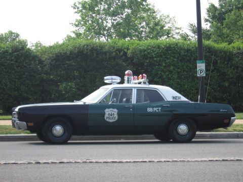 1991 Ford Crown Victoria - A vintage police car with "68 PCT" and "1745" markings is parked on a street.